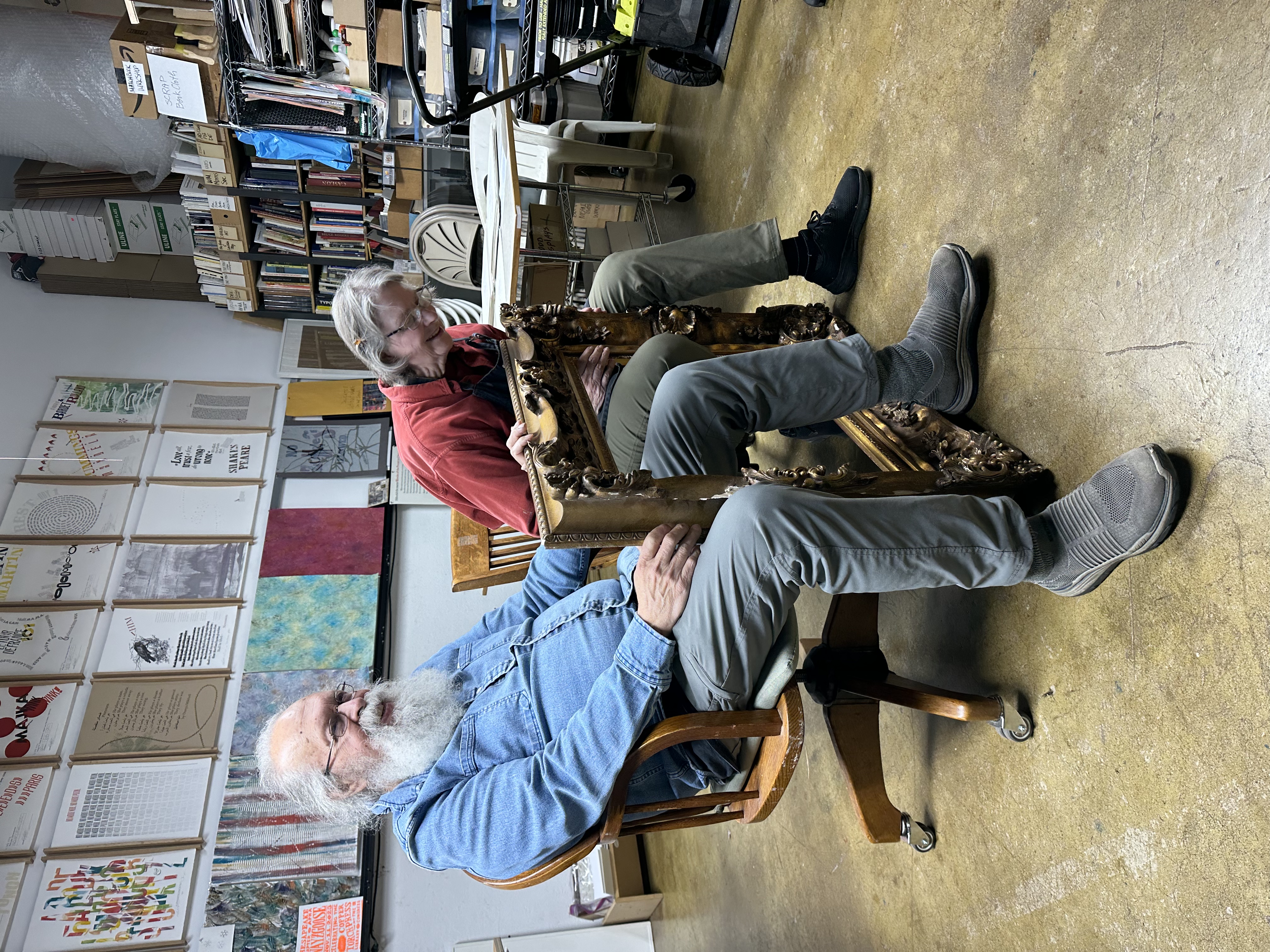 Two printers seated in a letterpress studio